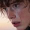 Close-up portrait of a young person with a tear on their cheek.
