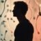 Man in silhouette before a staged installation of abstract sperm-shaped props.