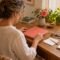 Woman organizing papers and a folder at a table.